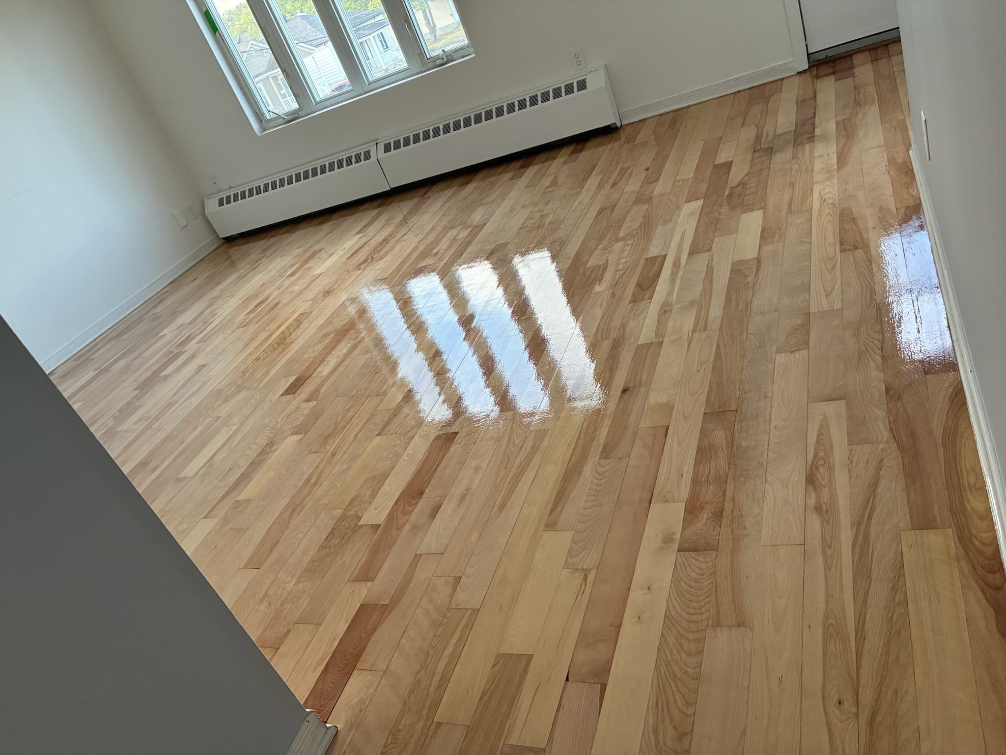 Plancher de bois naturel verni dans une pièce lumineuse